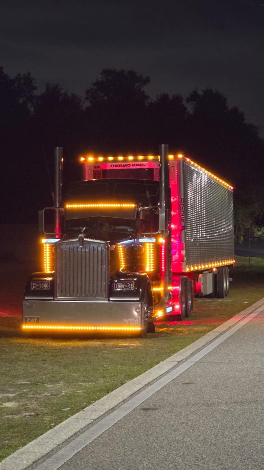 Kenworth with amber LED lighting and a Thermo King reefer at night